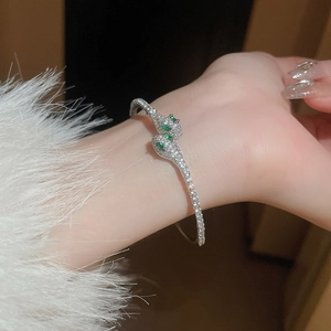 Exaggerated silver snake open bracelet with pavé cubic zirconia and green gem eyes