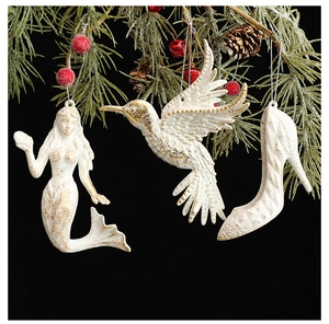 Décorations de Noël blanches et dorées avec sirène et colibri sur une branche de sapin