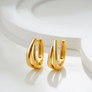 Macro view of two-tone gold and silver U-shaped hoop earrings with a polished finish