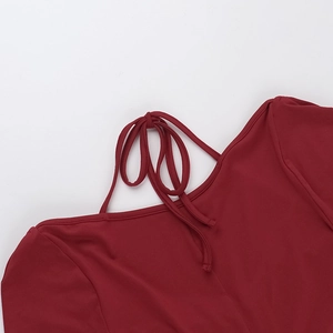 Détail du lacet de cou et du tissu doux d'une robe moulante rouge à manches longues