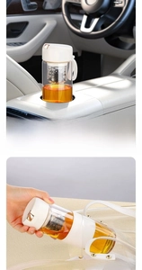 Detail of a portable glass tea cup with magnetic infuser and white carrying strap for car use