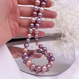 Macro shot of large pink and purple Baroque pearls necklace on a reflective mirror surface