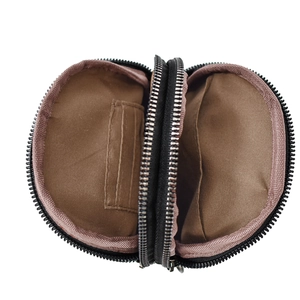 Detail showing dual zipper compartments and brown fabric lining of the canvas chest bag