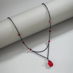 Macro detail of Gothic choker featuring dark red glass beads and a blood-drop pendant