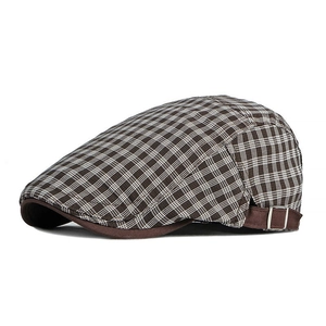 Détail de la boucle métallique réglable et du motif à carreaux sur une casquette plate