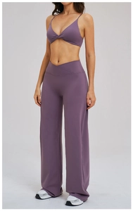Purple yoga set detail featuring criss-cross high waistband and wide-leg sports trousers