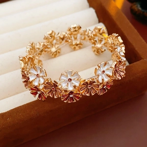 Makroaufnahme bunter Emaille-Blumenanhänger mit Goldbasis auf einer Schmuckschatulle