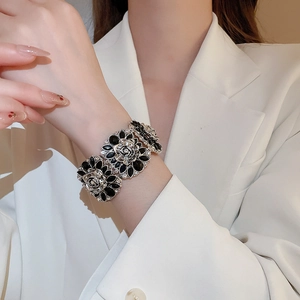 Detail of flower bracelet featuring silver frame with black petals and white rhinestones