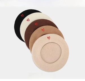 Detailed stack of wool berets with heart embroidery in black, beige, coffee, and camel