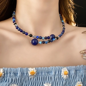 Macro detail of geometric beaded necklace with blue lapis beads and silver spacers