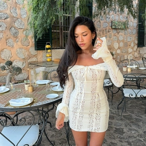 Detail of white lace off-shoulder dress with ruffled sleeves and lace-up chest design