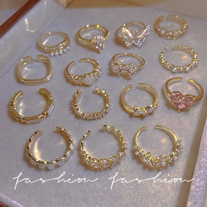 14-piece gold ring set featuring pearls, zircons, and pink heart charms in varied designs