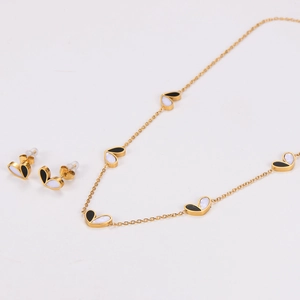 Macro shot of gold-plated heart jewelry set with black and white shell inlay detail