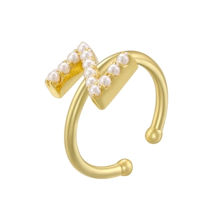 Detailed close-up of golden letter N ring with small pearls and a matte finish texture