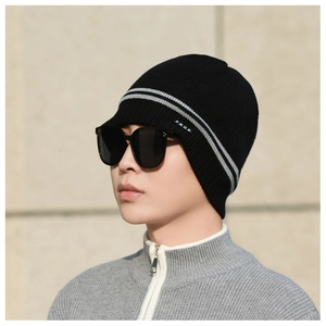 Detail of black winter knit beanie with FBQE label and gray stripes on outdoor model