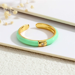 Detail of 18K gold-plated open ring with light green enamel and round clear zircon inlay