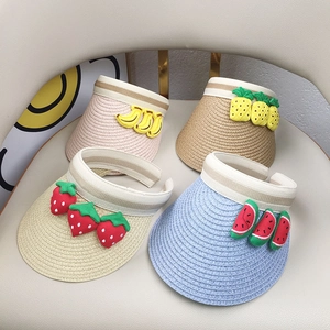 Detail of four breathable straw sun visors with cute fruit patches for toddlers