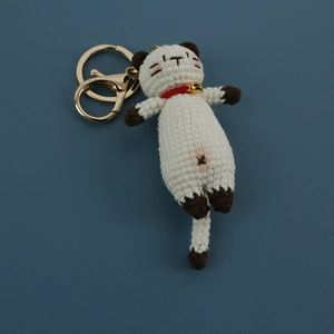Handmade crochet cat keychain in white and brown yarn with gold bell and ring