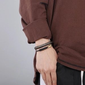Detail of double-layer men's punk bracelet featuring black woven leather and gold beaded chain