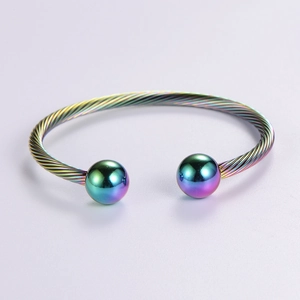 Adjustable iridescent twist wire open bangle with smooth metal beads on minimalist gray background