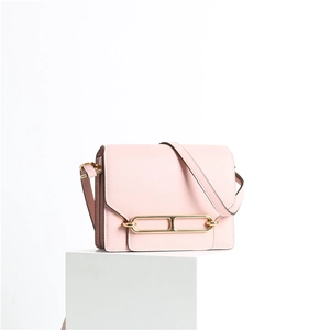 Dettaglio borsa a tracolla in pelle rosa con fibbia dorata e texture a grana fine