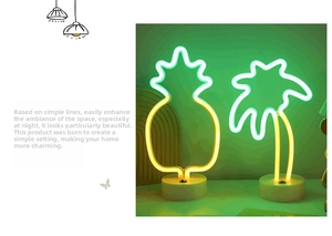 Detail of pineapple and coconut tree neon LED lights with tropical warm yellow glow