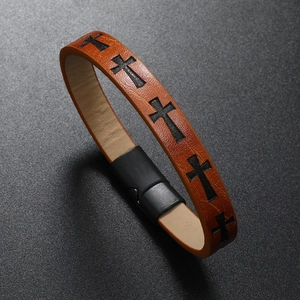 Macro detail of brown leather multilayer bracelet featuring black cross patterns and magnetic clasp