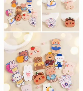 Detail of cute acrylic cartoon bear and rabbit brooches with soft cream and brown tones