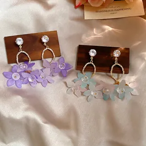 Sparkling zircon flower drop earrings with frosted petals on elegant silk background