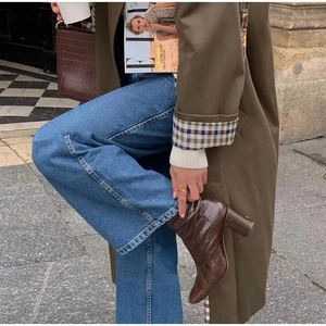 Detail von braunen Stiefeletten in Krokoprägung mit Blockabsatz und Street-Style-Outfit