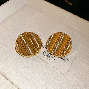 Golden ripple textured circular acrylic stud earrings with a shiny metallic mirror finish