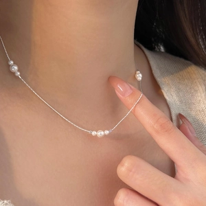 Close-up of elegant S925 sterling silver pearl necklace on model neck