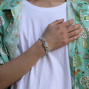 Close-up of silver Cuban link bracelet with pavé-set clear zircons worn by a model