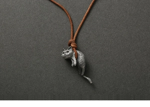 Macro shot of retro 925 sterling silver cat pendant with textured fur and brown cord