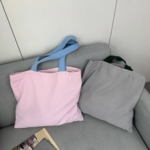 Close-up of pink and black striped canvas tote bags showing fabric texture and wide straps