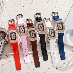 Group shot of diamond-encrusted tonneau watches in six colors on marble background