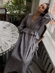 Détail de robe plissée lavande avec ourlet à volants et manches bouffantes lanternes