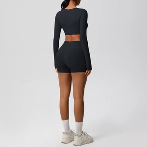 Rear view of black two-piece yoga set featuring long sleeve crop top and high waist shorts