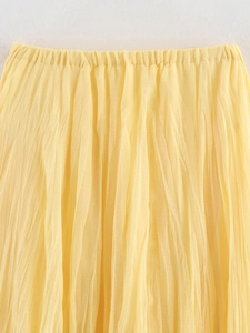Détail de la taille haute élastique et de la texture plissée sur jupe midi jaune