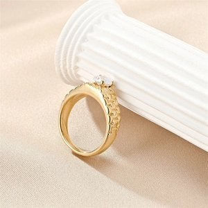 Macro view of gold-plated titanium ring featuring scale texture and zircon inlay