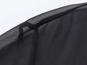 Dettaglio ravvicinato del tessuto in chiffon nero semitrasparente e cuciture rifinite