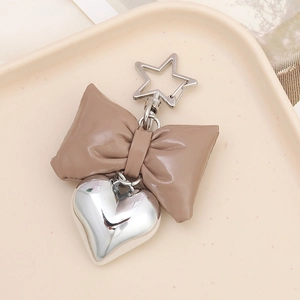 Detailed view of a brown faux leather bow keychain with a silver 3D heart charm and star clip