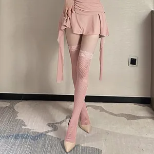 Detailed view of pink lace fishnet thigh-high stockings paired with high heels