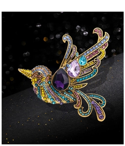 Detailed view of hummingbird brooch with colorful rhinestones and purple gemstones