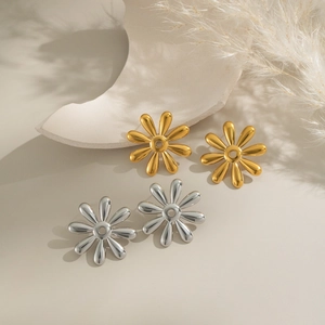 Elegant 18k gold and silver floral stud earrings displayed on a minimalist background