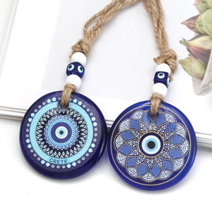 Detailed close-up of blue evil eye pendants with mandala patterns and Crete text