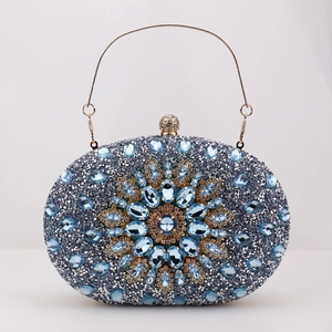 Close-up of blue crystal evening clutch featuring a gold handle and floral rhinestone patterns