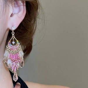 Nahaufnahme von Bohemian-Quastenohrringen mit rosa Perlen und Kristallen an einem Model