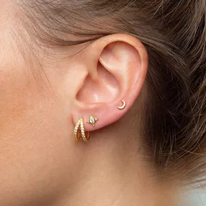 Macro view of gold S925 silver hoop earrings with zircon star and moon studs on ear