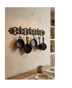 Détail de décoration murale de cuisine en fonte avec crochets lys et mini ustensiles